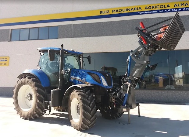 Tractor New Holland azul con pala frontal delante de Ruiz Maquinaria Agrícola Almazán